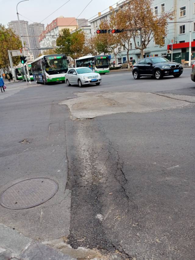 威海路与长春路交叉路口马路上,沥青路面凹陷缺失